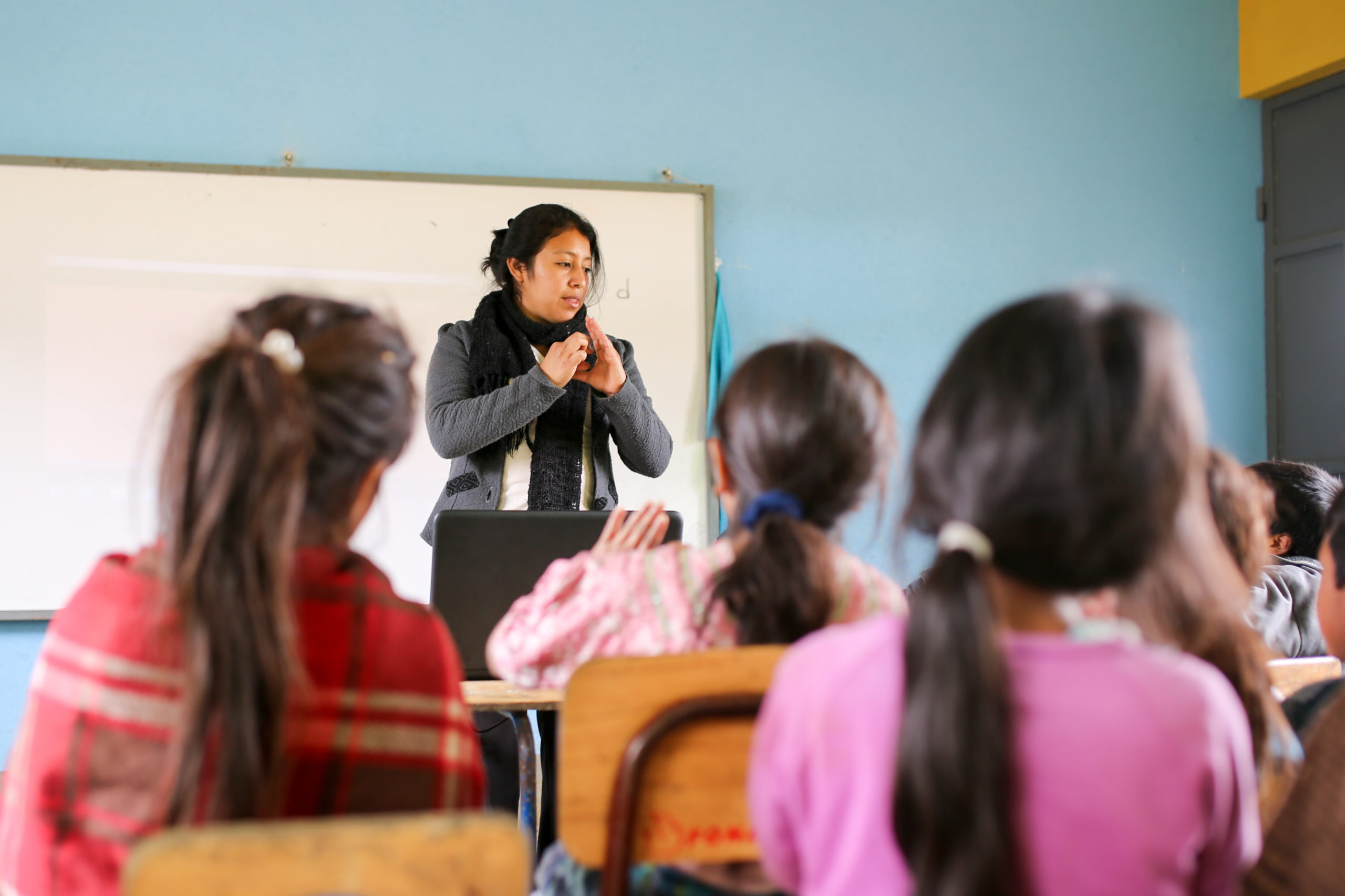 Photo description: A teacher in Guatemala leads a lesson at the front of a classroom | Photo credit: Amanda Brown